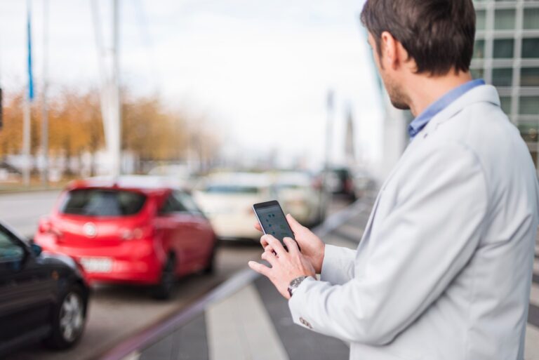 Businessman looking for a car with his car sharing app