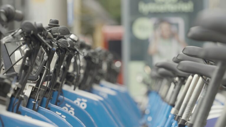 Rows of bicycles for rent. Action. A lot of identical bikes are in row. Street bikes for rent in